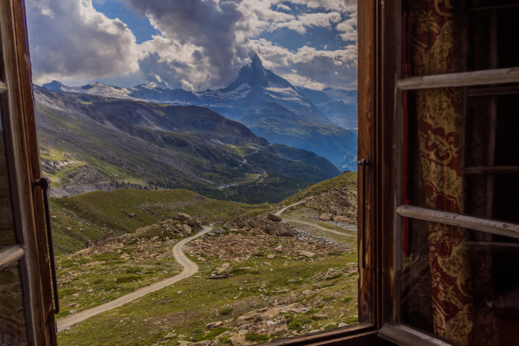 Das Foto zeigt den Blick aus einem geöffneten Fenster der Fluealphütte Richtung Matterhorn.